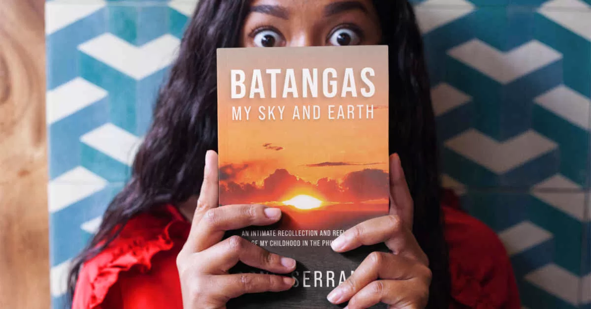 Surprised woman holding a copy of Batangas: My Sky and Earth