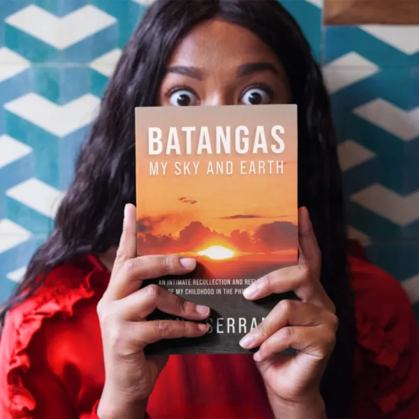 Person with a surprised expression holding a copy of Batangas: My Sky and Earth